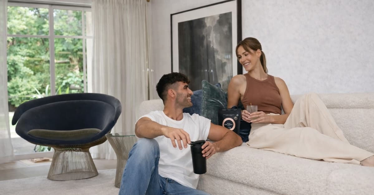 Couple relaxing at home enjoying Tropeaka wellness drink during healthy lifestyle routine