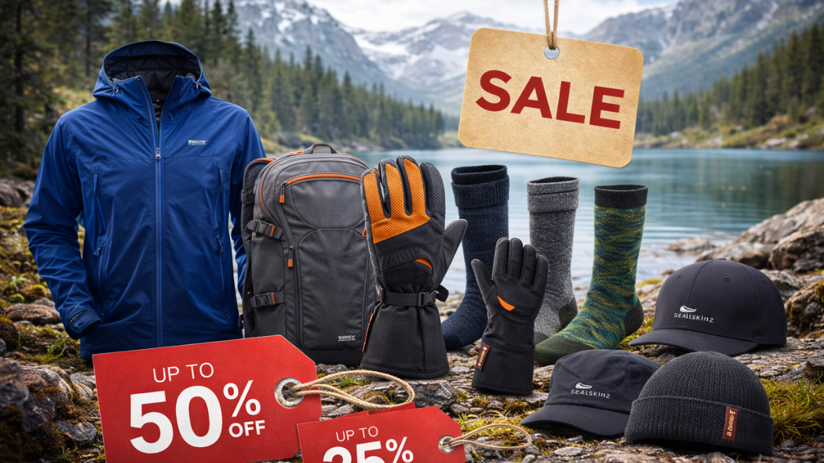 Sealskinz waterproof jacket, backpack, gloves, socks, and hats displayed on rocky ground beside an alpine lake with sale tags showing up to 50 percent off.